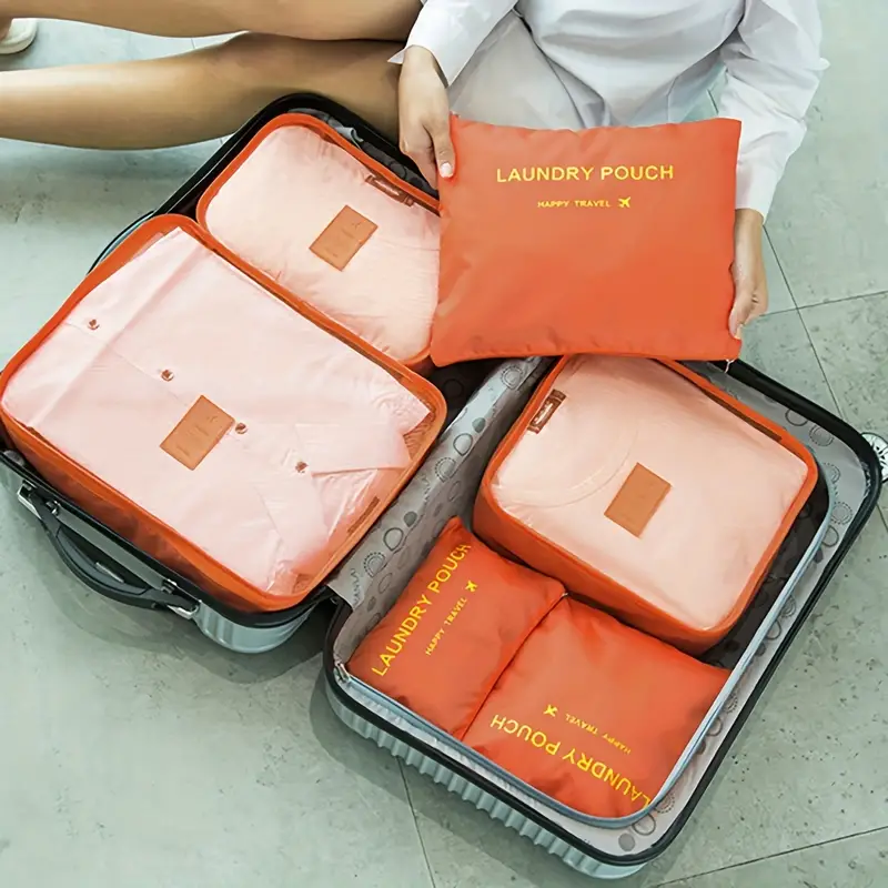 a woman sitting on a suitcase with a lot of clothes in it