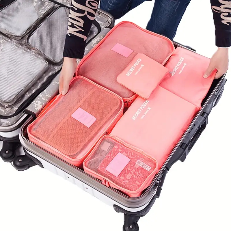 a person holding a suitcase with packing cubes